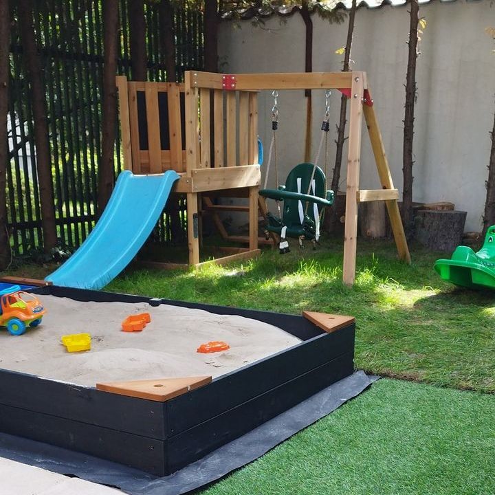 The Wioska garden with a sandpit, slide and swing